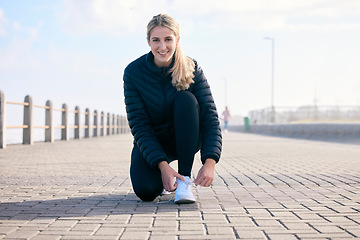 Image showing Portrait, shoelace and happy woman runner at beach with performance, preparation or warm up. Fitness, shoes and face of girl with positive, mindset or smile before run, training and workout exercise