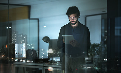 Image showing Business man, tablet and serious in office, online browsing or web scroll by window with city lights at night. Technology, working late and professional person with touchscreen for research deadline.