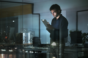 Image showing Night, news or businessman with tablet in office to search digital technology, data analytics or global media. City view, entrepreneur or focused person typing on iot dashboard or networking online