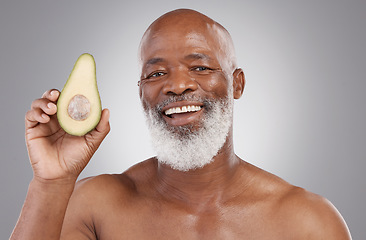 Image showing Senior black man, avocado and portrait smile for healthy skincare or natural nutrition against a gray studio background. Happy African American male smiling with fruit for skin healthcare or wellness