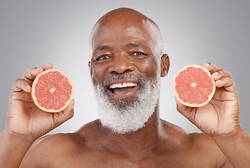 Image showing Senior black man, grapefruit and smile for vitamin c, healthy skincare or natural nutrition against gray studio background. Portrait of happy African male with fruit for skin, healthcare or wellness