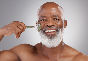 Image showing Face roller, portrait and smile for senior black man with skincare, stone or dermatology product in skin glow. Elderly, cheek or facial jade roll for male model in self care for anti aging for beauty