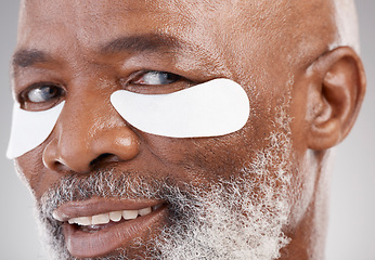 Image showing Skincare, collagen and eye mask for a portrait of black man with smile, happiness or anti ageing face treatment. Closeup dermatology, grooming or happy mature model with patches on eyes for skin care