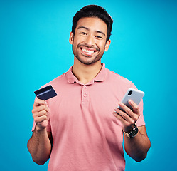 Image showing Man with smartphone, credit card and smile in portrait, ecommerce and fintech isolated on blue background. Online shopping, internet banking and finance, technology and male with bank app in studio