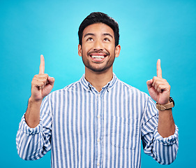 Image showing Man is pointing up, marketing and promotion with happiness and branding isolated on blue background. Opportunity, deal or announcement with advertising, news and promo ad with male person and smile