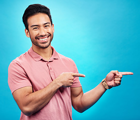 Image showing Point, mockup and portrait of Asian man on blue background for news, information and announcement. Advertising, studio mockup and male pointing for branding copy space, promotion and show gesture