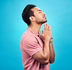 Image showing Man is praying, religion and faith with worship to God, belief and spirituality isolated on blue background. Male person in prayer, Christian and gratitude with mindfulness and peace in studio