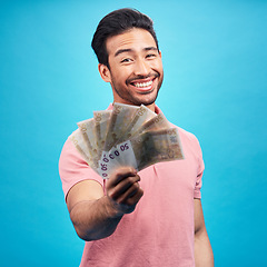 Image showing Man in portrait, money fan with financial freedom and cash, prize or reward isolated on blue background. Finance with savings, bonus and payment, happy male person with economic success in studio