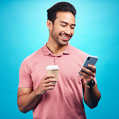 Image showing Smile, coffee and man with phone in studio isolated on a blue background. Tea, cellphone and happiness of Asian person with drink, caffeine and mobile for social media, typing online or texting.