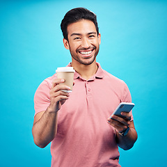 Image showing Coffee, happiness and portrait of man with phone in studio isolated on a blue background. Tea, cellphone and smile of Asian person with drink, caffeine and mobile for social media or typing online.