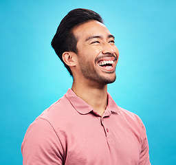 Image showing Funny comedy, laughter and man in studio isolated on a blue background. Comic, humor and Asian person laughing at joke, happiness and carefree for hilarious smile, excited and cheerful with emoji.