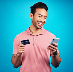 Image showing Happy man with smartphone, credit card and smile, ecommerce and fintech isolated on blue background. Online shopping, internet banking and finance with technology and male with bank app on phone