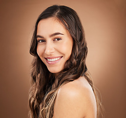 Image showing Beauty, portrait and woman in studio for hair, treatment and cosmetics against a brown background. Haircare, face and girl smile for natural, curly or wavy, texture or keratin, textures and confident