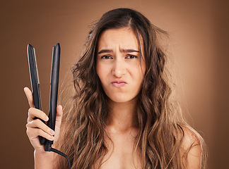 Image showing Hair care, electric straightener and portrait of sad woman on studio background, worried face and dry salon hairstyle. Haircare damage, flat iron and frustrated latino model with spa heat treatment.