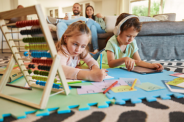 Image showing Floor, learning and children with parents relax on sofa for education, creative writing and online digital games at home. Kids on carpet with tablet, headphones and stationery with family on couch