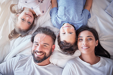 Image showing Top view, smile and family on bed, love and bonding with quality time, break and relax together. Portrait, happy parents and mother with father, children and siblings in bedroom, happiness and peace