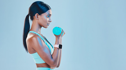 Image showing Sports, workout and female with weights in studio for arm or strength training with motivation. Fitness, exercise and Indian woman athlete with dumbells isolated by blue background with mockup space.