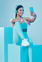 Image showing Woman, fitness and selfie in studio with headphones, wellness and training clothes by background. Gen z model, training and fashion with streaming music, body goals or exercise for health by backdrop