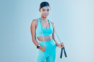 Image showing Fitness, skipping rope and mockup with a sports woman in studio on a blue background for health or wellness. Exercise, mindset and space with a young female athlete training for cardio or endurance