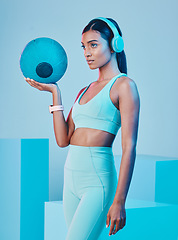 Image showing Fitness, ball and woman in studio with music for training, exercise and sports routine on blue background. Headphones, radio and Indian female athlete with weight and podcast, mindset and focus