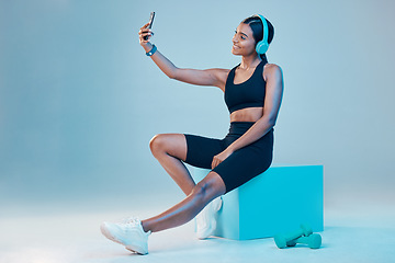 Image showing Woman, fitness and selfie in studio with music, wellness or training clothes by background. Gen z model, influencer girl and fashion with streaming, profile picture or exercise for health with smile