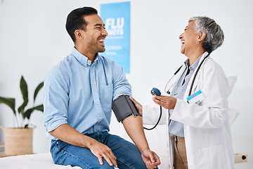 Image showing Doctor, patient and blood pressure consultation in hospital while laughing and talking about health. Medical professional woman and man with cuff for hypertension, healthcare and wellness check