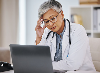 Image showing Woman doctor, laptop and stress or headache in hospital office while working online for research. Medical professional female with anxiety, burnout and depression for healthcare results