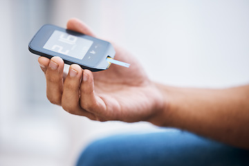 Image showing Hand, diabetes and measurement with a man in his home holding a blood glucose meter for disability awareness. Healthcare, medical and sugar with a diabetic male testing insulin levels in his house