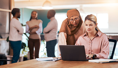 Image showing Business people, laptop and serious mentor talking to woman at office desk for motivation. Entrepreneur women together for discussion about management, planning or online training with muslim coach