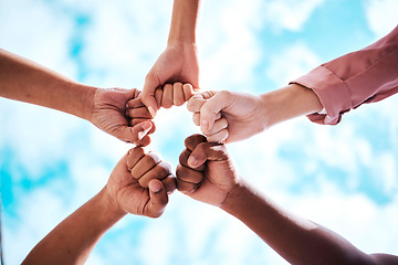 Image showing People, hands and fist bump in collaboration, trust or unity for partnership, community or diversity with sky below. Diverse group touching hands for teamwork, success or motivation in solidarity