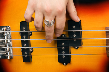 Image showing Hand of the artist on guitar strings