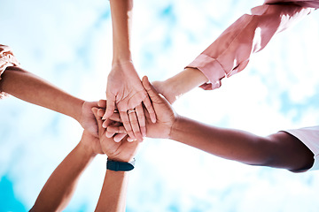 Image showing Hands stacked, motivation and team building on a blue sky for trust, community and about us. Mission, support and friends in a low huddle for success, celebration and solidarity together as a group