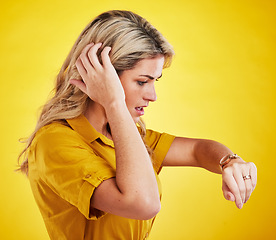 Image showing Watch, late and woman checking the time in a studio with a shock, scared and surprise face expression. Panic, anxiety and confused female model with a wristwatch isolated by a yellow background.