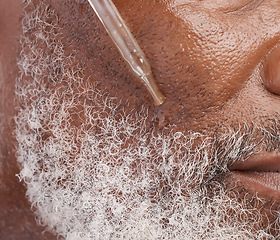 Image showing Skincare, serum and face of senior man in studio for wellness, cosmetics and facial hair care. Dermatology, beauty and closeup of male person with oil dropper for anti aging, wrinkles and grooming