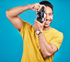 Image showing Happy, photographer and man with a camera in a studio for creative or artistic photoshoot. Photography, happiness and portrait of a male person with a hobby for memories isolated by a blue background