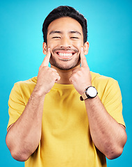 Image showing Happy, smile expression and portrait of a man expressing happiness, joy and cheerful face. Young, confident and a person smiling for positivity and confidence isolated on a blue background in studio