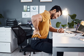 Image showing Business man, night and back pain or stress at office desk in a modern workplace . Asian male entrepreneur with injury and health, physical or burnout problem while tired and working late