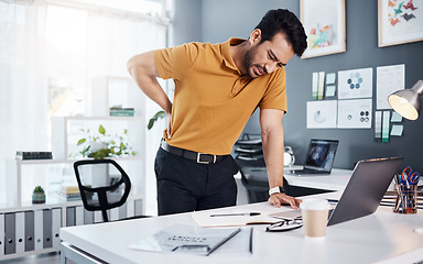 Image showing Business man, stress and back pain at office desk with a injury and issue. Asian male entrepreneur with technology and frustrated with body ache, mental health or burnout problem while tired