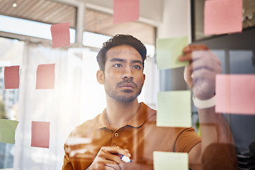 Image showing Planning, writing and focused man on glass for project management, workflow and business schedule. Asian person brainstorming ideas, moodboard and sticky notes for solution, reminder or job priority