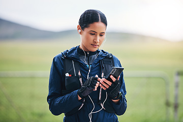 Image showing Music, phone check and woman in the countryside ready for fitness and exercise. Sports, training and mobile headphones of a female athlete looking at gps with audio and web radio for workout