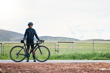 Image showing Woman, athlete and bicycle in countryside, mockup on sky and training for triathlon, sports and goals. Female cyclist, bike and fitness gear with motivation, freedom or thinking of cardio performance