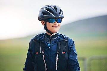 Image showing Happy woman, cycling athlete and thinking in nature for exercise, training and triathlon sports. Female cyclist, bike helmet and glasses for fitness gear, motivation and freedom of cardio performance