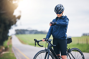 Image showing Cyclist woman, check time and nature on road for speed, gps and heart rate with fitness, health and wellness goal. Cycling, bicycle and female athlete with watch for exercise, training and workout