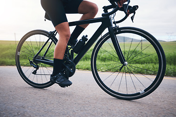 Image showing Closeup, legs and athlete on bicycle outdoor for exercise, training and triathlon sports. Person, bike and cycling on road for freedom, cardio fitness and performance with speed, power and transport