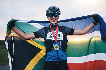 Image showing Winner sports, happy woman from South Africa with flag and gold medal winning, outdoor cycling race or triathlon. Happiness, win and cyclist with smile, fitness and world record with national pride.