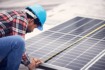 Image showing Technician, measuring tape and solar panel on rooftop for check, planning or renewable energy project. Black man, photovoltaic system and roof installation with focus, sustainable building or service