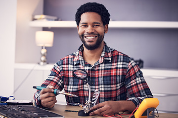 Image showing Technician portrait, man and fixing electronics of computer hardware, soldering iron tools or tech repair. Maintenance, magnifying glass or electrical fix for happy African male working on technology