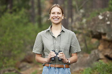 Image showing Binocular, forest and portrait of happy woman hiking for nature journey, jungle adventure and travel in outdoor explore. Face of a young person birdwatching and trekking in eco friendly green woods