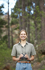 Image showing Binocular, nature and portrait of happy woman hiking in forest journey, jungle adventure and travel or outdoor explore. Face of a young person birdwatching and trekking in eco friendly, green woods