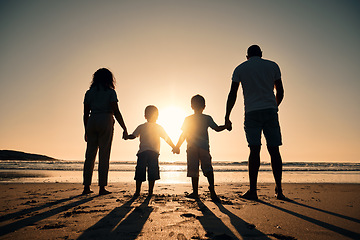 Image showing Family silhouette at the beach, holding hands at sunrise and people with love, care and support outdoor. Mom, dad and kids travel, back and ocean view with parents and children outdoor in nature